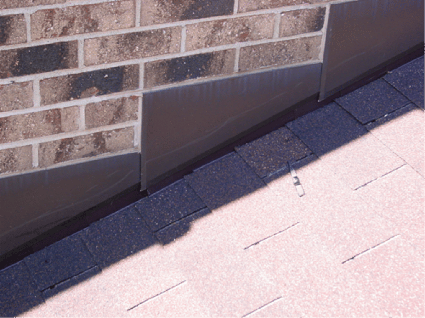 <p>flashing covering and protecting the intersection of a wall and the sloping part of a roof, consisting of L-shaped pieces that step down to follow the slope of the roof</p>