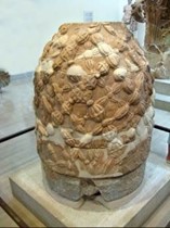 <p>The ‘omphalos’ at the sanctuary of Apollo in Delphi (fig.), was a stone object considered to be the navel of the world. Explain why such an object should exist there?</p>