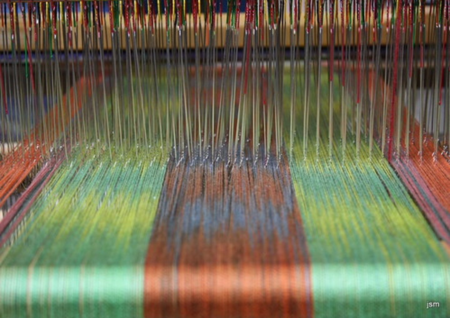 <p>two sets of threads are interlocked in a perpendicular pattern. This can be done by hand or by machine. The length-wise threads are called the warp and are held stationary on a loom while the other thread (weft) is passed back and forth between them.</p>