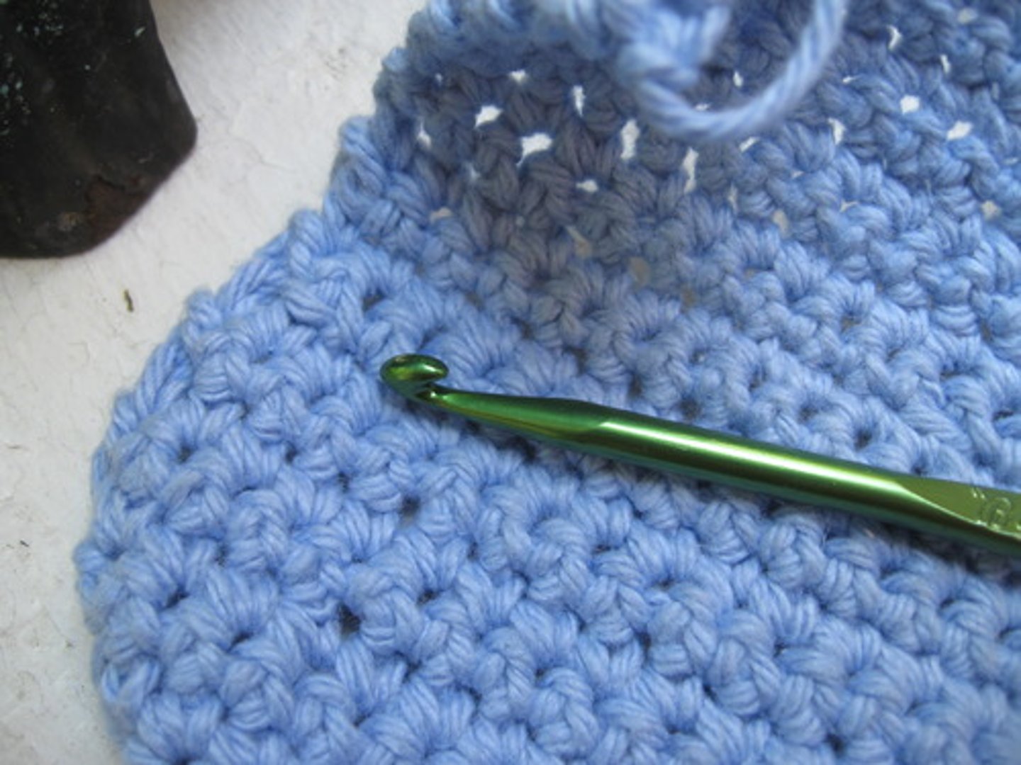 <p>involves using a stick with a hook at the end, called a crochet hook, and creating stitches to interlock the yarn into a fabric or pattern. With crochet, each stitch is finished before starting the next, whereas in knitting, many stitches are kept open at the same time.</p>