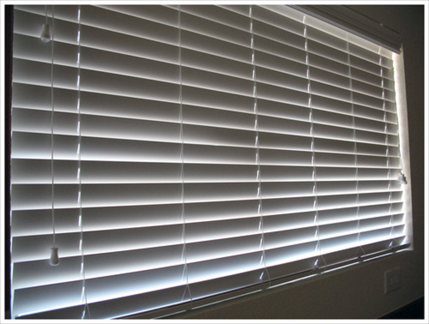 <p>a cover for a window made of a single piece or strips of cloth, paper, or plastic that is pulled up or down by a string</p>