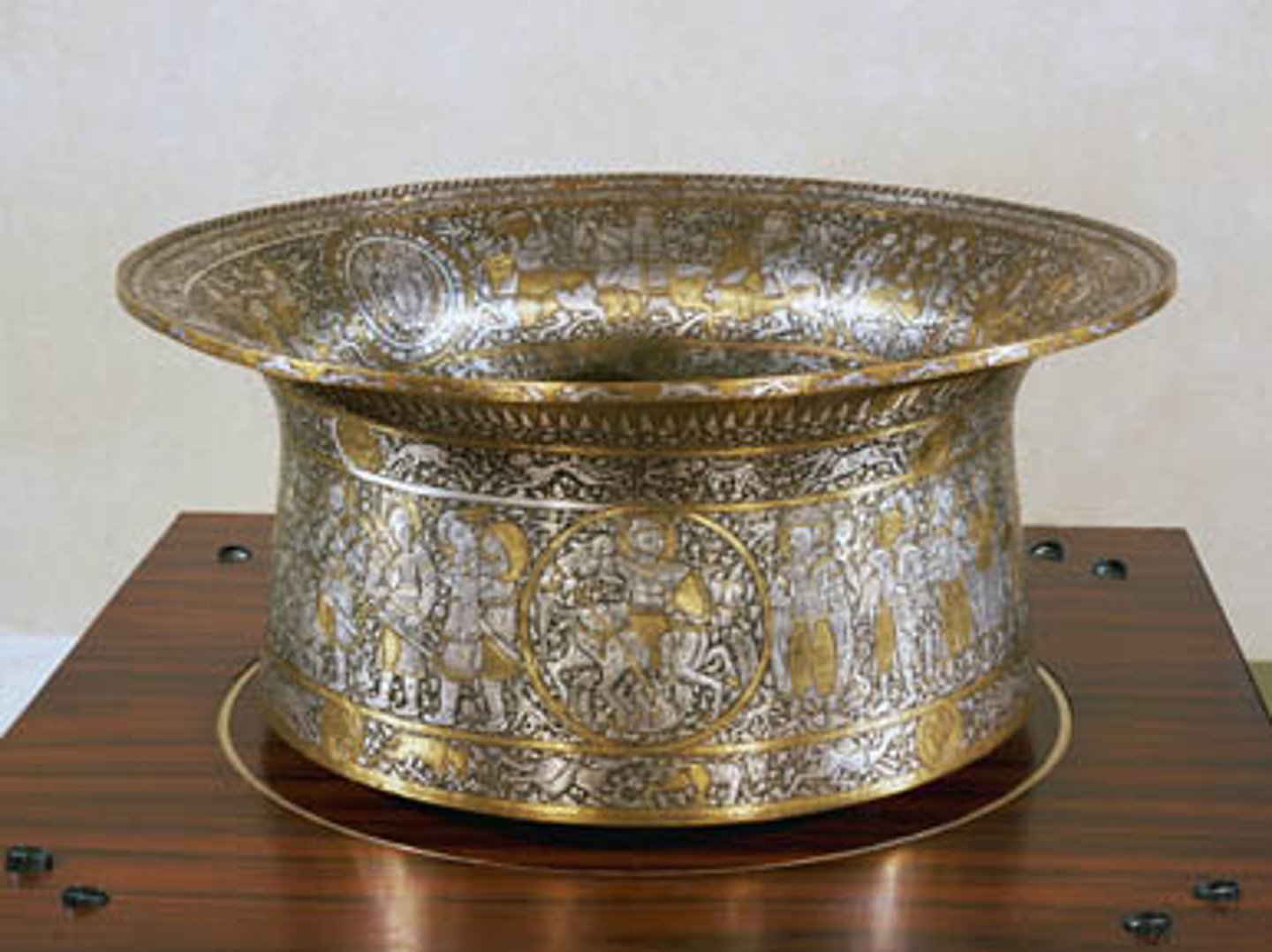 <p>1320-1340. Muhammed ibn al-Zain. Niello with brass inlaid with gold and silver.<br>Niello: Black paste used to enhance lines of an engraving<br>Signed SIX TIMES!!!!!<br>Patron is unknown... could have been used as a banquet dish or for ritual hand washing. Later used for baptisms.<br>Maybe a gift? To a sultan?<br>Outside:<br>Mamluk court scenes, hunting and battle scenes. (Mamluks were a North indian muslim empires)<br>4 roundels depicting horsemen, 20 Mamluk officials in court finery, and mongols (ENEMIES!!)<br>Inside:<br>Hunting scenes, animals, coat of arms (FLUER DE LIS added LATER by the french..)<br>Aquatic animal imagery on the bottom!!! Fish, eels, crabs, frogs. ALLUDE to the basin holding WATER? PURPOSE<br>HORROR VACUI! Also pricey materials = LUXURY GOOD</p>