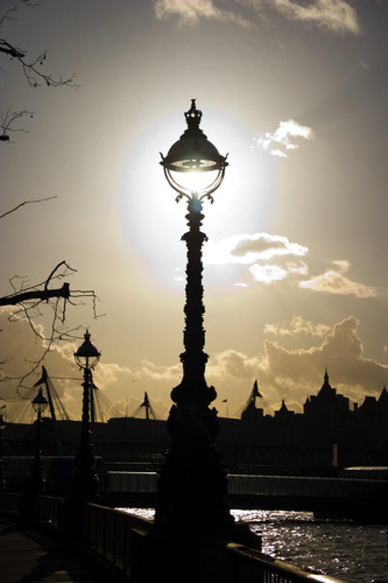 <p>a light in or at the side of a road or public area that is usually supported on a tall post</p>