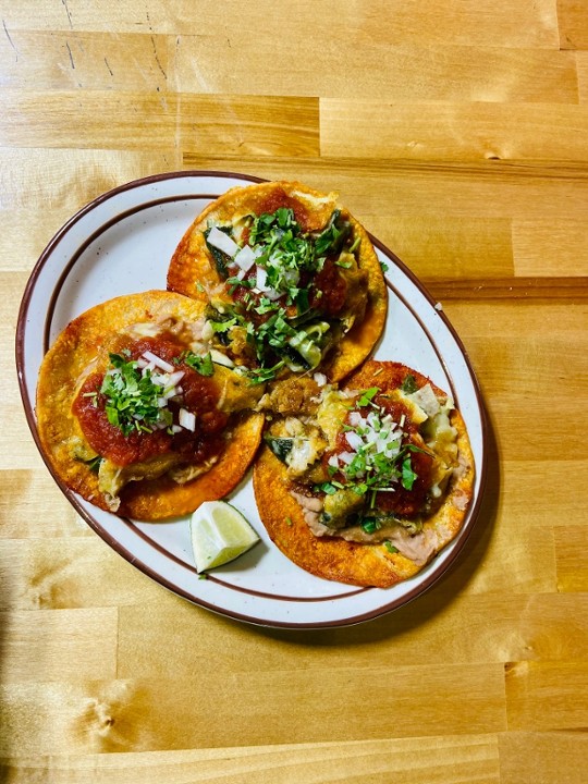 <p>Three red tortillas smeared in refried beans, cheese stuffed poblano peppers, your choice of ranchero or green sauce, topped with cilantro and onions, and served with rice.</p>