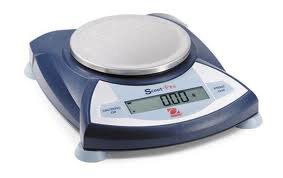 A balance that has a flat metal circular platform and an electronic digital display