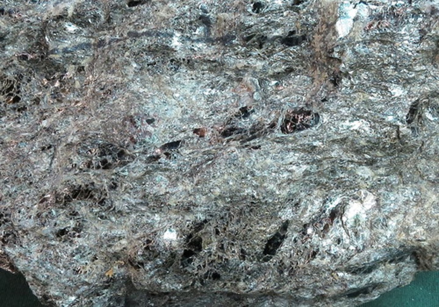 <p>A medium- to coarse-grained, foliated rock in which the grains are easily seen and identified by eye or with a hand lens or microscope. Sheet silicates are abundant (typically muscovite and biotite). Large crystals of garnet and other minerals may be visible, though in this example the large crystals are mostly biotite</p>