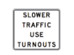 <p>There are five vehicles following closely behind you on a road with one lane in your direction. When you see this white sign, you should:</p><ul><li><p>Drive to the right edge of your lane but keep moving</p></li><li><p>Slow down and signal the other drivers to pass you</p></li><li><p>Drive to the side of the road and stop in the designated area</p></li></ul>