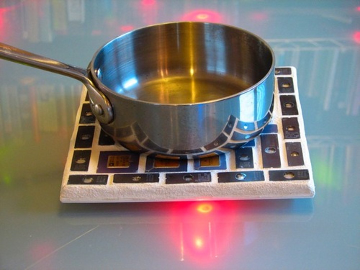 <p>A white ceramic tile with a wood frame that is used as a surface to place hot objects until they cool.</p>