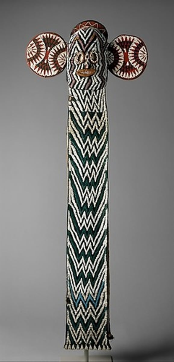 <p>Bamileke (Cameroon, western grasslands region)</p><p>c. 19th to 20th century CE</p><p>Form: Wood, woven raffia, cloth, and beads</p><p>Function: Worn by only elite members of the elephant society</p><p>Members of the Kuosi elephant society, including royals, warriors, and wealthy elite wore the masks during ceremonial dances. The masks made of wood, woven rathia, cloth, shells, and beads have large ears and a long panel in the front. They're meant to look like the ears and trunk of an elephant. The geometric designs and patterns are symbolic of strength and royalty.</p>