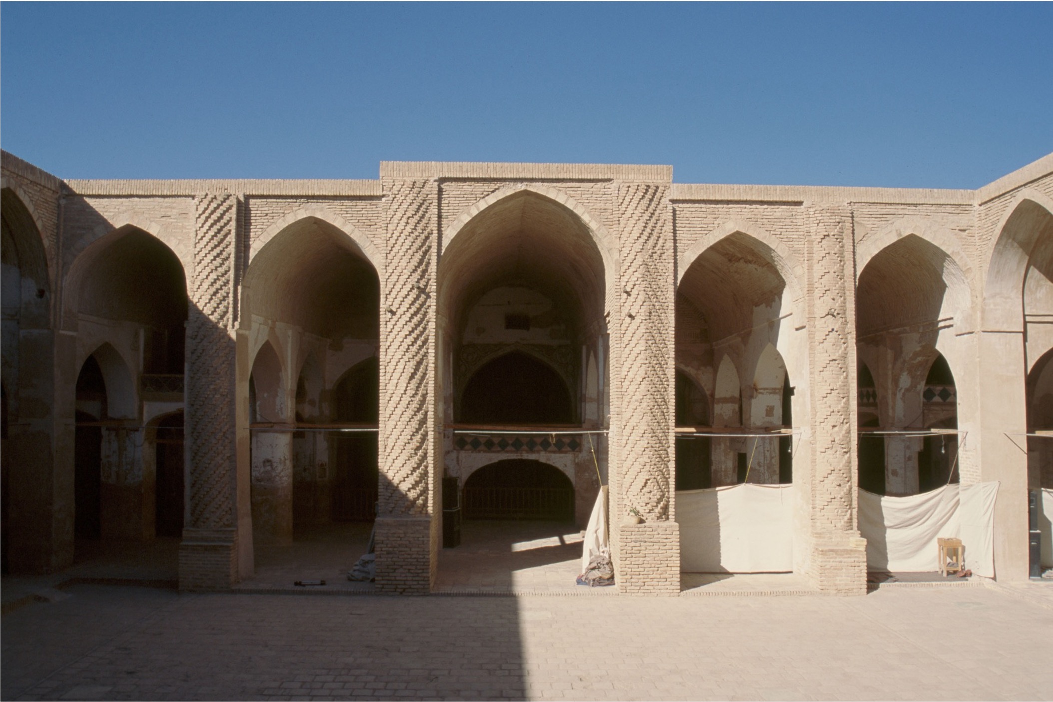 <ul><li><p>Smaller mosque (much smaller than the “imperial” Abbasid mosques)</p></li><li><p><strong>Distinctive minaret</strong></p></li><li><p>Most important development in the area was the consistent use of the iwan</p></li><li><p>Hypostyle, with very heavy columns and piers, vaulted ceilings, and three domes in the mihrab area</p></li><li><p>Does not use spolia, and the brickwork is very heavy and stumpy with low ceiling vaults</p><ul><li><p>Built to be warm in the winter (easily heated)</p></li></ul></li><li><p>Designs on the columns showing influence of Samarra C</p><ul><li><p>Repeated rosette designs, but each one is slightly different</p></li><li><p><strong>Horror Vacui – “Fear of Emptiness”</strong></p></li></ul></li></ul><p></p>