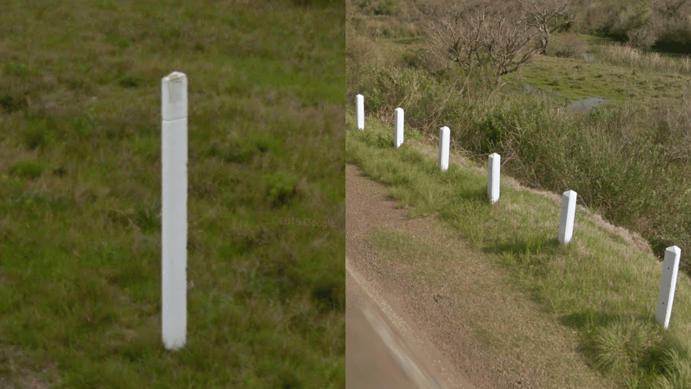 <p>White bollards and stone barriers</p>