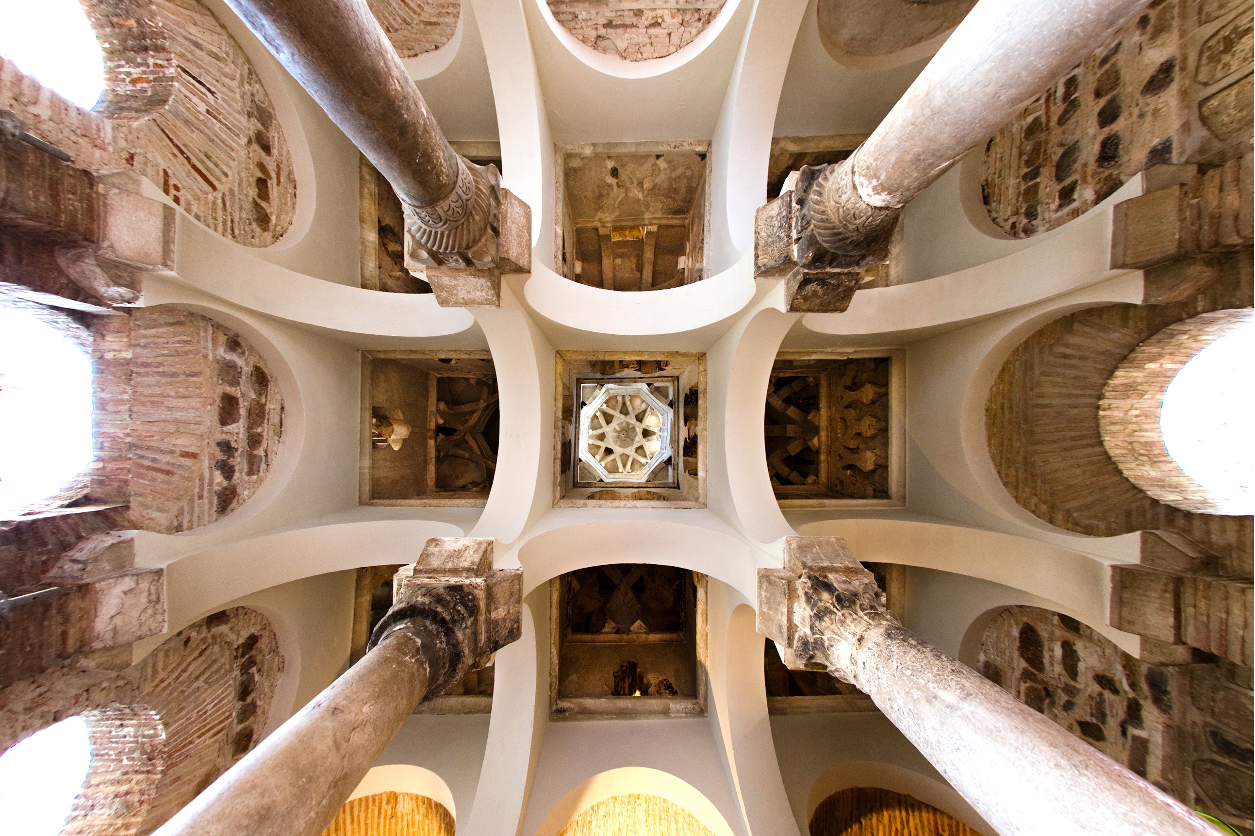 <ul><li><p>One of the seven remaining mosques in Spain – it was converted to a Catholic church</p></li><li><p><strong>Use of many of the elements in the Great Mosque of Cordoba, but on a much smaller scale</strong></p></li><li><p>In theory a hypostyle hall, it is a simple, nine-compartment room; <strong>each compartment has a different style dome</strong></p></li><li><p>Simple, repeated geometric forms give the room an unsurpassed serenity</p></li><li><p>The columns and capitals are spolia from Visigothic monuments</p></li></ul><p></p>