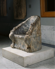 Large, solid thrones for royalty or gods in theater. Often made of stone