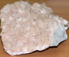 <p>colorless streak, perfect fracture in 3 directions, vitreous luster, pink/flesh/white color. occurs mainly in dolomitic limestone and marble. effervesces (bubbles) slightly with cold HCl dilution, but powder effervesces freely. may occur as rhombohedral crystals with curved crystal faces.</p>
