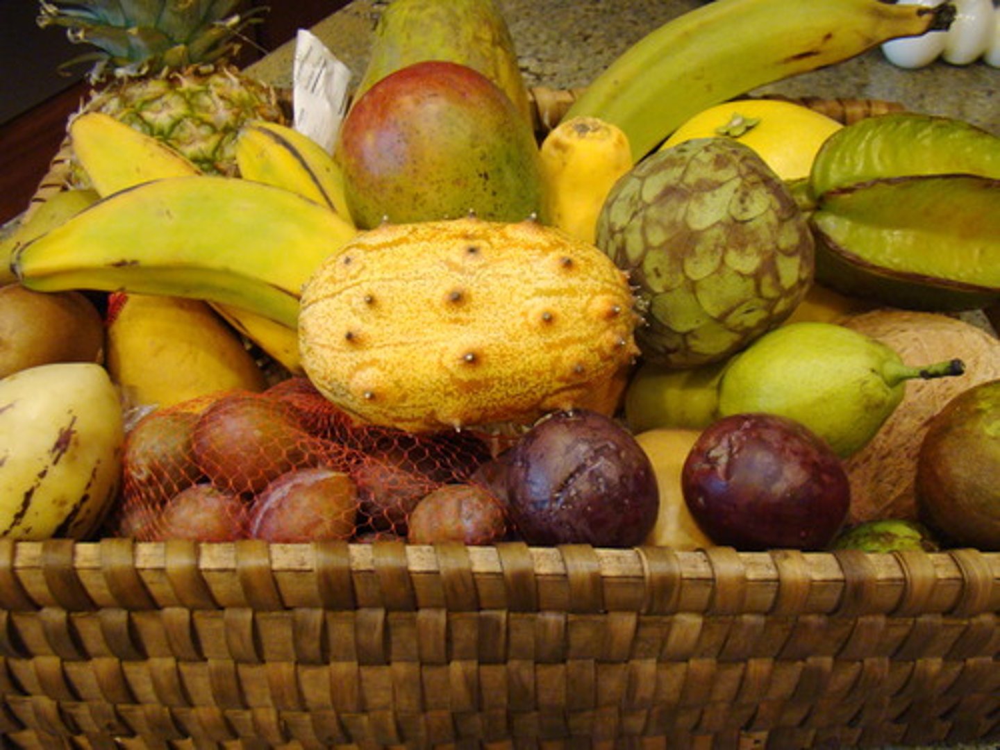<p>unusual and exciting because of coming (or seeming to come) from far away, especially a tropical country</p><p>~ flowers/food/designs</p>