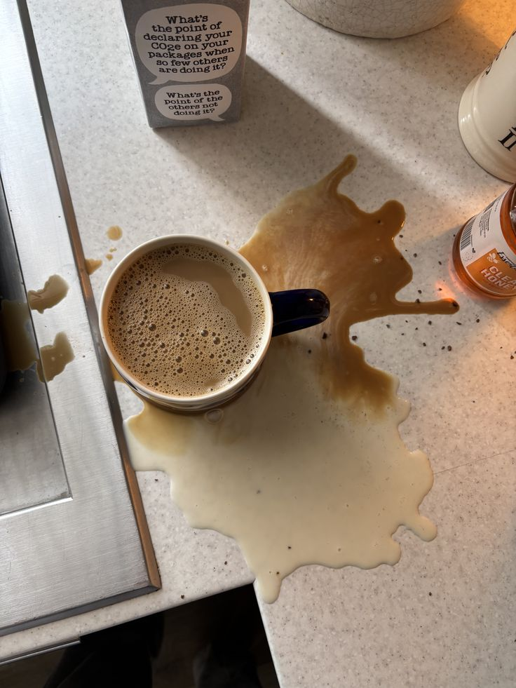 <p>the coffee is <strong><u>spilling out of</u></strong> the cup</p>