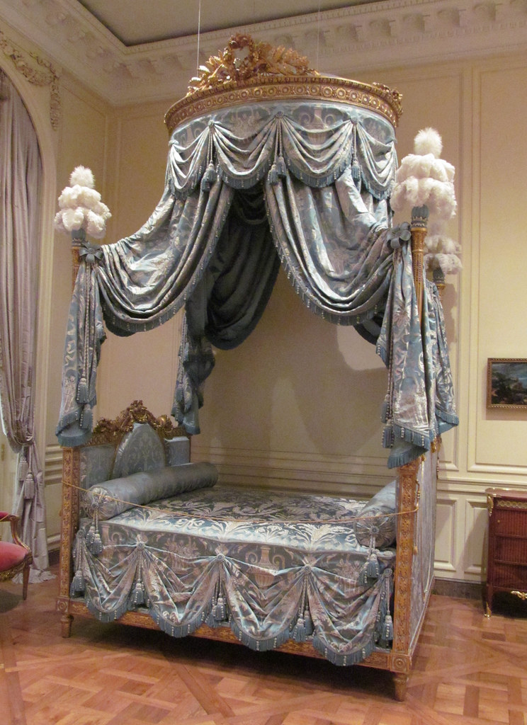 <p>a bed set lengthwise against the wall and surmounted by a small dome</p>