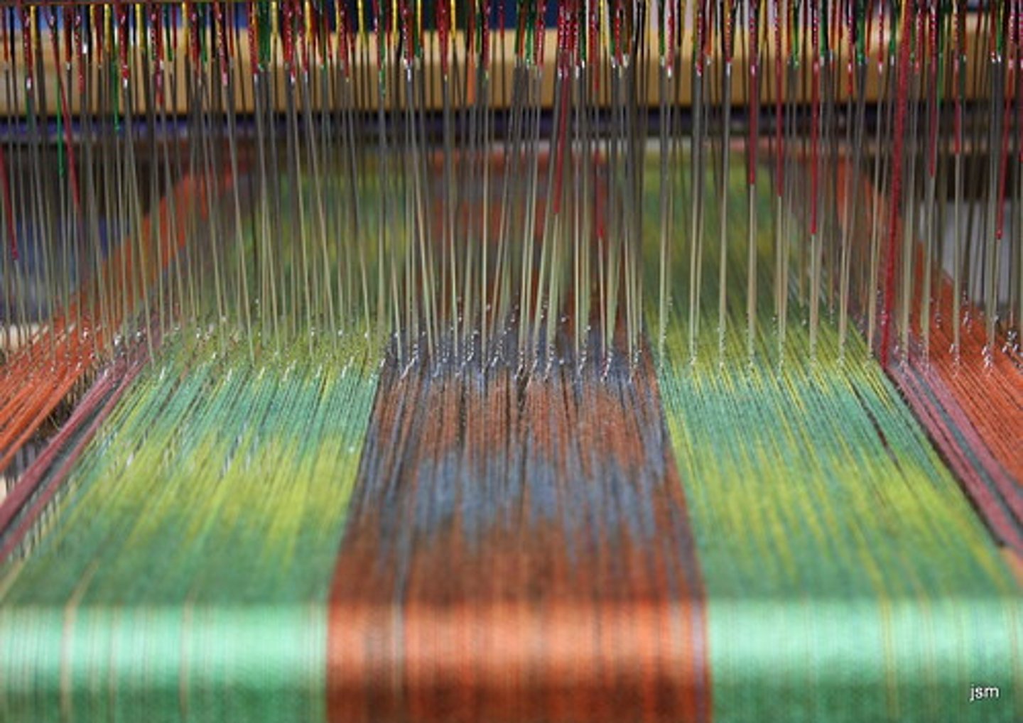 <p>using a loom to interlace of two sets of threads at right angles to each other: the warp and the weft</p>