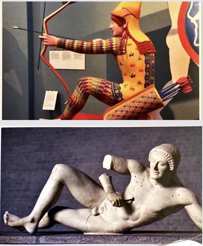 * The **central apex is occupied by Athena** with a **bronze spear**, maker her more imposing and powerful as **it glistened in the sun** ​
* She stands frontally, though her legs are sideways, wearing a thick peplos and her aegis**, armed** with a helmet, spear and shield ​
* **she presides ove**r but **does not engage**, with no gestures towards the chaotic fighting unfolding around her​
* The **fighting is arranged outwards** around Athena​
*  The soldiers next to Athena have their **backs towards her**, separating her further from their engagements.​
*  the sculptors utilised the awkward triangular shape to showcase a **variety of poses** and a **series of mini-conflicts and engagements without repetition**​

\
* Archer on the  left of the pediment is identified as **Paris** because of his role as an **archer** and **eastern clothing** ​
* He is in a **mid action pose,** about to fire an arrow ​
* He is **bent down on his right knee** (filling the space) and looks ahead at his target, **resting delicately on the heel** of his left foot and the knee of his right ​
* Unlike other warriors he wears **long-sleeved and long-legged clothing** (others naked) painted with **bright colours**​
* It captures Paris as **slightly effeminate** as common **contemporary attitude to easterners** ​
* He **skill as an archer** is perhaps praised, and the **fallen warriors** on the left side of the pediment could be **his victims** ​

  \
* The surviving figure immediately to the left of Paris appears to just have been hit, holding himself up while the furthermost figure is dying ​
* He is very reflective of the Archaic style; his face holds the typical Archaic style at odds with death (the **Archaic smile**)​
* His **folded legs appear almost casual** as a further contrast to his state (his right leg is bent as the knee, folded over his lying left leg) 