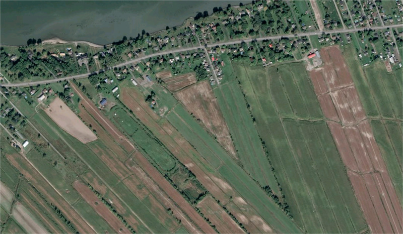 <p>a linear settlement where land is divided into narrow, rectangular lots that extend back from a river or road, giving each person equal access to the resource</p>