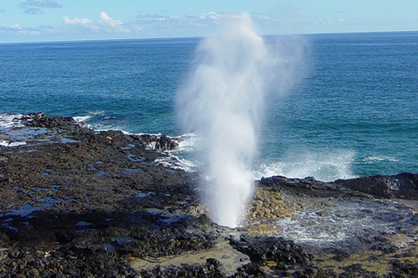 <p>= when a weakness/crack in the cliff is enlarged by wave erosion, forming a cave and part of the roof has fallen in to form a blowhole<br><br>... waves rushing into the cave may then splash up the blowhole inland</p>