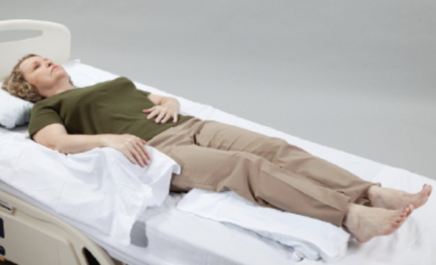 <p>Notice the use of pillows under the legs for heel protection and to guard against knee flexion contractures. Also notice the elevation of the right wrist and hand.</p>