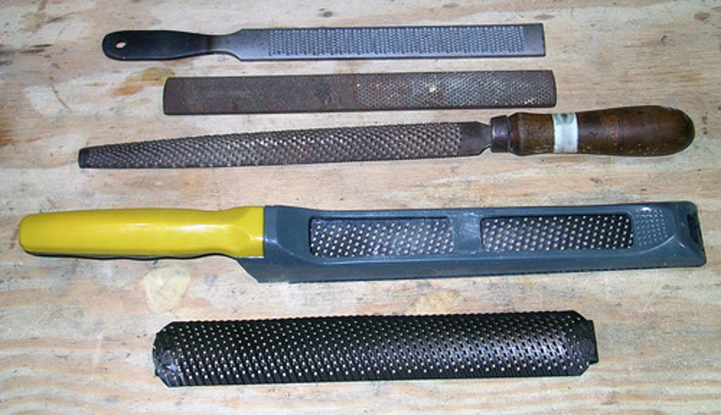 <p>flat steel tools with a rough surface, which can be used to wear away excess stone.</p>