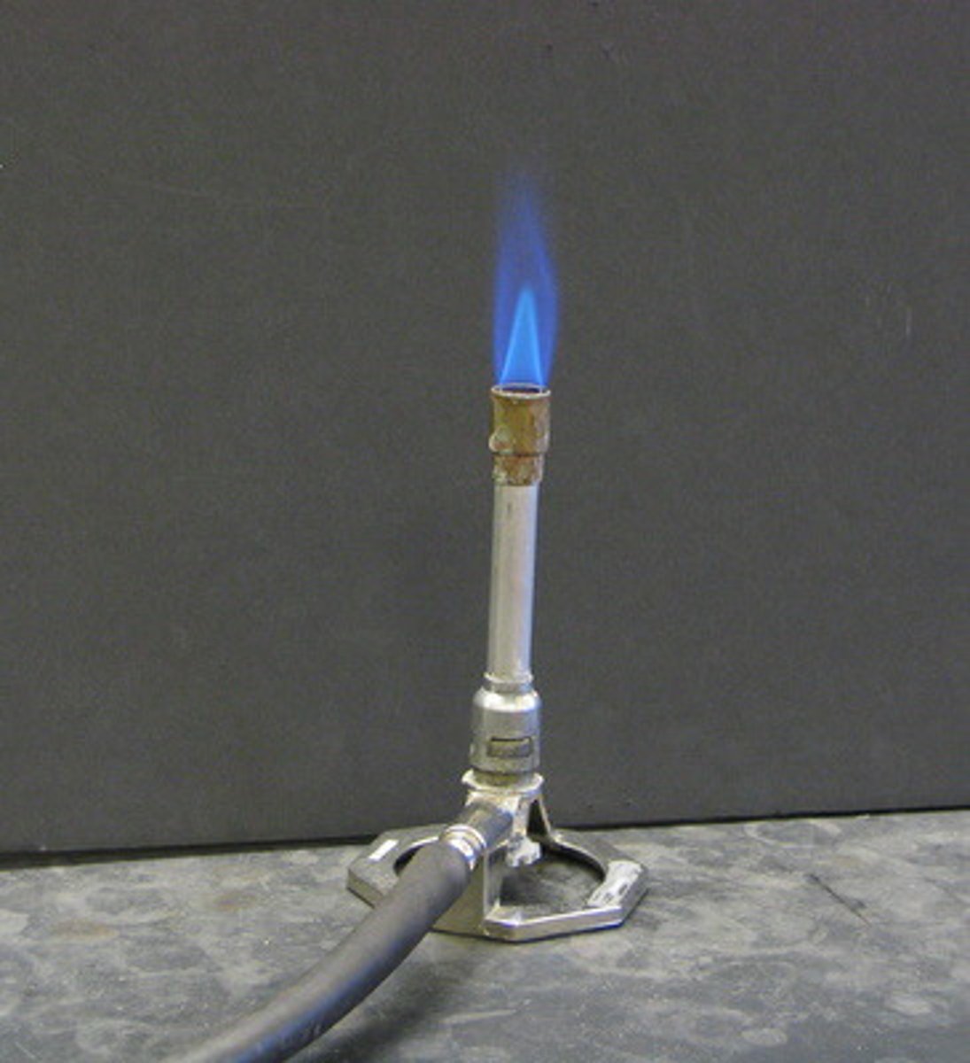 <p>A cylindrical metal piece of equipment that mixes a gaseous fuel sample with the oxygen in the air to enable combustion of the fuel to occur when the reaction is initiated by a match or a spark.</p>
