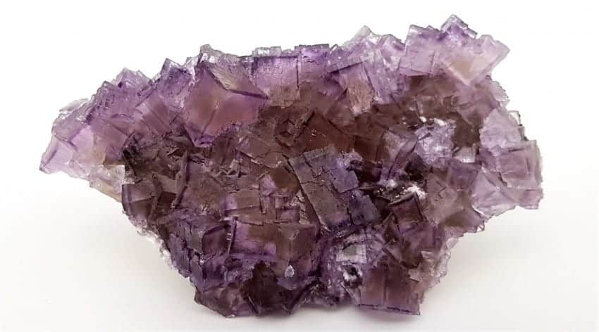 <p>Amplia gama de colores intensos (morado, verde, azul, amarillo), a menudo zonados en un mismo cristal. Brillo vítreo. Exfoliación octaédrica perfecta (4 direcciones). Comúnmente forma cristales cúbicos. Dureza 4. Puede presentar fluorescencia bajo luz UV.</p>