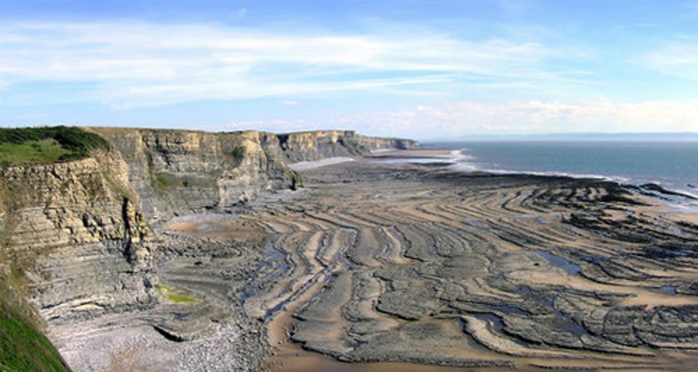 <p>a flat area along the base of a cliff produced by the retreat of the cliff as a result of erosive processes.</p>