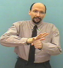 <p>Place hands into the sign for “location”; then, with bonds hands stuck together, <strong>bounce up and down twice</strong>; use facial expressions</p>