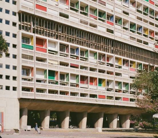 <p><span><span>Massive concrete housing block, colorful balconies</span></span></p>