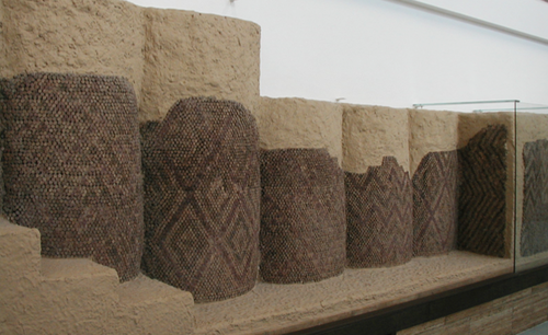 <p>small clay cones which, pointed end first, have been pressed tightly together into a wall coated with a thick layer of wet plaster.</p>