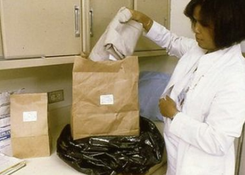 This forensic nurse is ensuring that each evidentiary item is handled carefully and individually packaged in a paper bag.