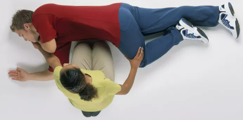 <p>Use your free hand to bend the person's knee farthest away from you to a right angle.<span> </span>Carefully roll the person onto their side by pulling on the bent knee towards you<span>. Their bent arm should be supporting the head, and their extended arm will stop you rolling them too far. Make sure their bent leg is at a right angle.</span></p>