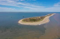 <p>narrow projections of sand or shingle that are attached to the land at one end. they extend across a bay or where the coastline changes direction. they are formed by longshore drift powered by strong prevailing wind. the area behind the spit is sheltered where slt and mud is depositev creating a saltmarsh</p>