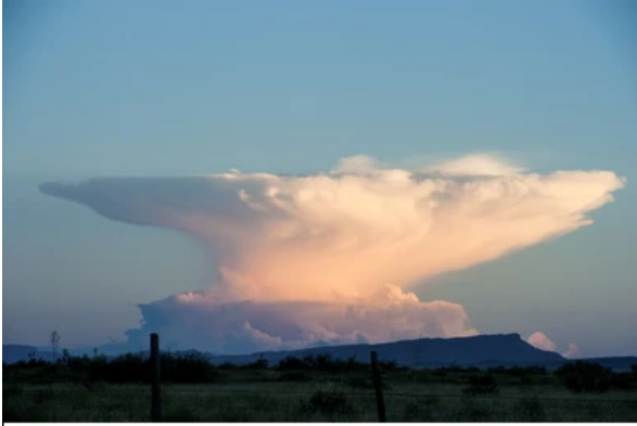 <p>This is an anvil cloud and it is associated with severe super-cell thunderstorms</p>