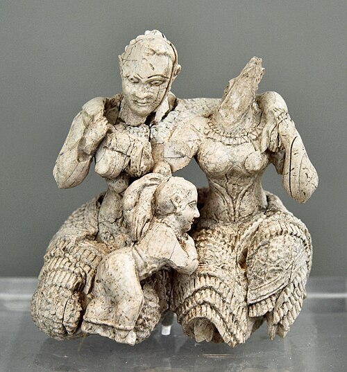 <p>Sculpture of a child ( god ?) with two bare-breasted women </p>