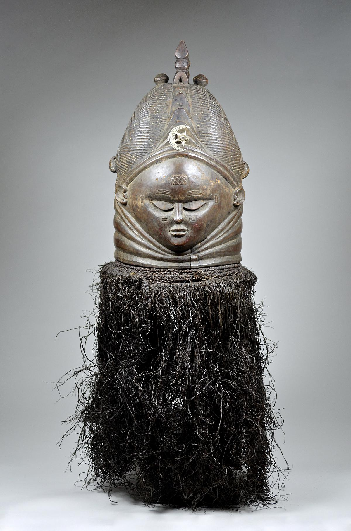 <p>“Bundu Mask” Sande Society, Sierra Leone, 20th century, Wood, cloth, and Fiber</p><p>Visuals: smooth, <strong>dark </strong>surface (polished, used in ritual), Ripples = COULD BE.. 1) symbol of fertility 2) representation of the water spirit, high forehead = wisdom/intelligence, small closed mouth = woman who doesn’t gossip (ideal), downcast eyes = modesty/respect, elaborate hairstyle = beauty</p><p>Functio: performed at coming of age ceremonies for females in Sande Society, MODELS  IDEAL  female appearance AND behavior</p><p>Context: uninitiated girls painted white (unattractive), mask is worn <em>on top</em> of head → raffia covers performer - allows spirit to embody performer</p>