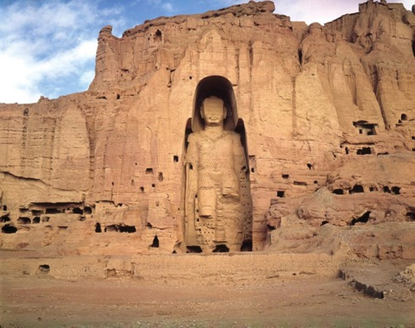 <p>400-800, destroyed 2001 🙁. Cut rock with plaster+paint. Afghanistan<br>Bamiyan located along SILK ROAD, considered a commerce/religious center<br>First colossal Buddha statue, area was carved around so worshipers could CIRCUMAMBULATE<br>Originally covered in stucco then faced in pigment + gold<br>Hundreds of galleries are carved in the cliff, some with murals of the seated murals, some with stairs to climb onto his shoulders<br>DESTROYED - ICONOCLASM</p>