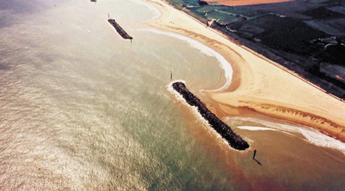 <p>a barrier built out into a body of water parallel to coast; protect a coast or harbor from the force of waves; create calm area for boats; lead to greater deposition of sand, displacing water</p>