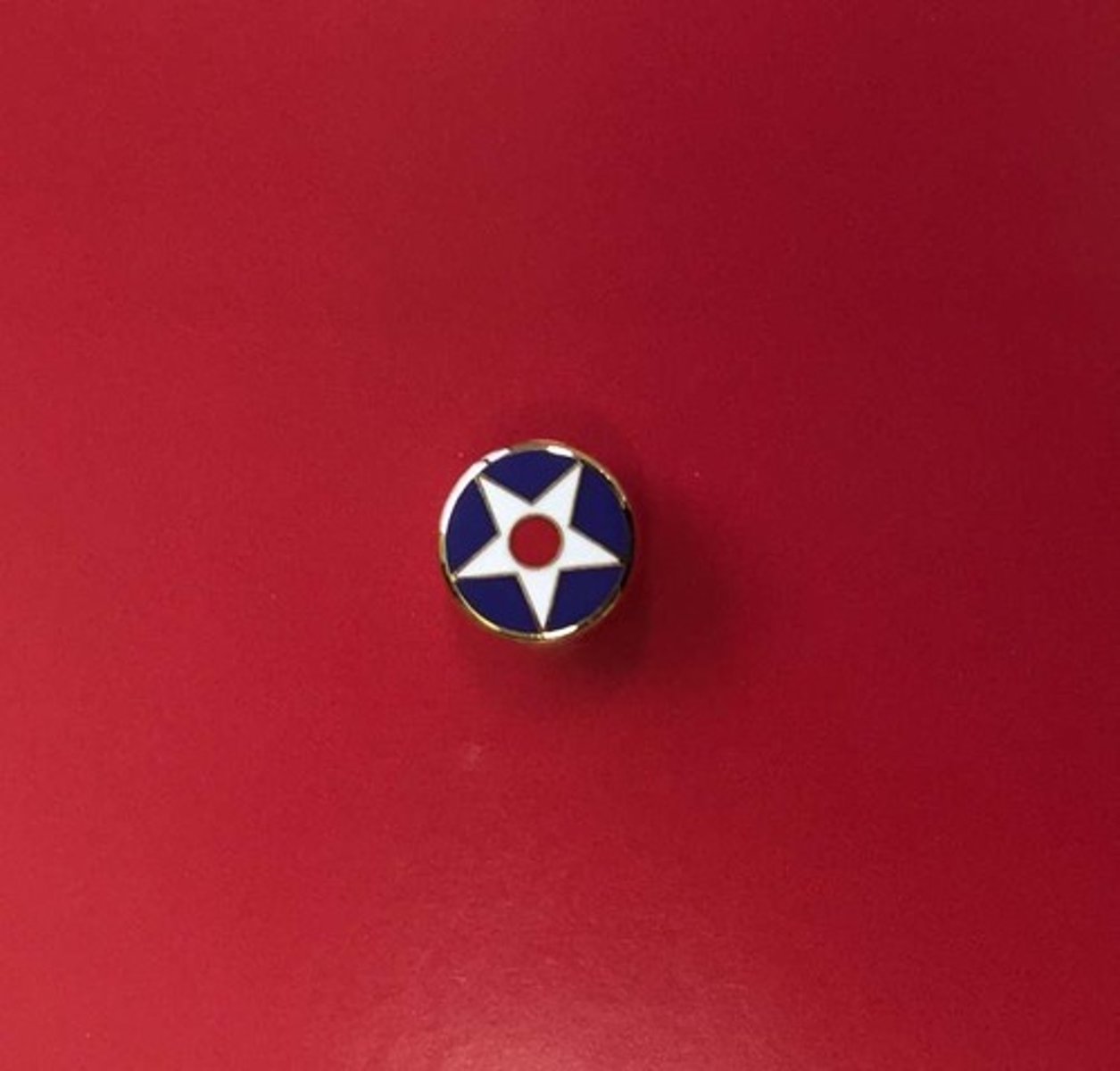 <p>- Circular and bears the white star and cardinal ball of the Society</p>