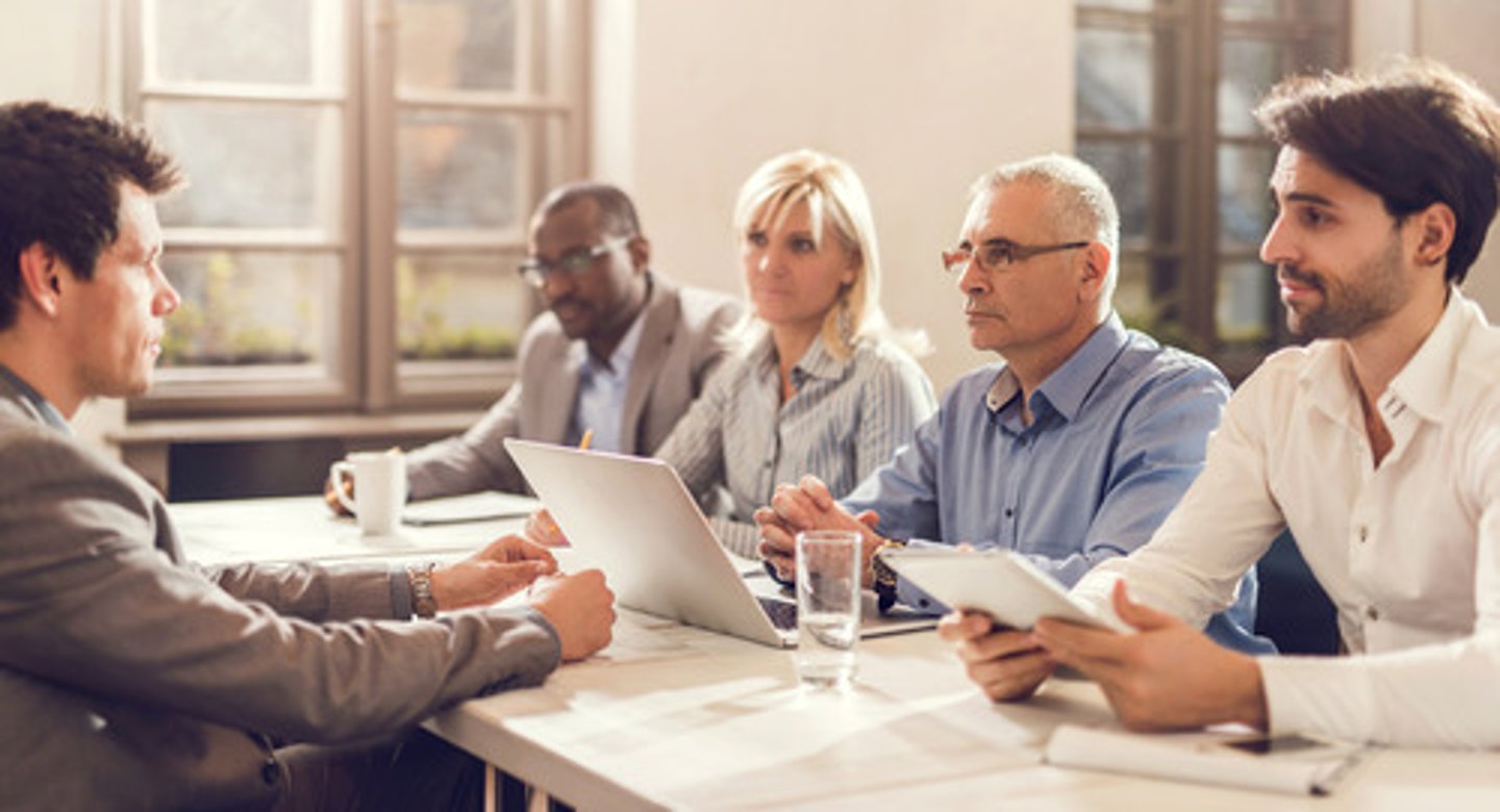 <p>the group of people interviewing someone for a job</p>
