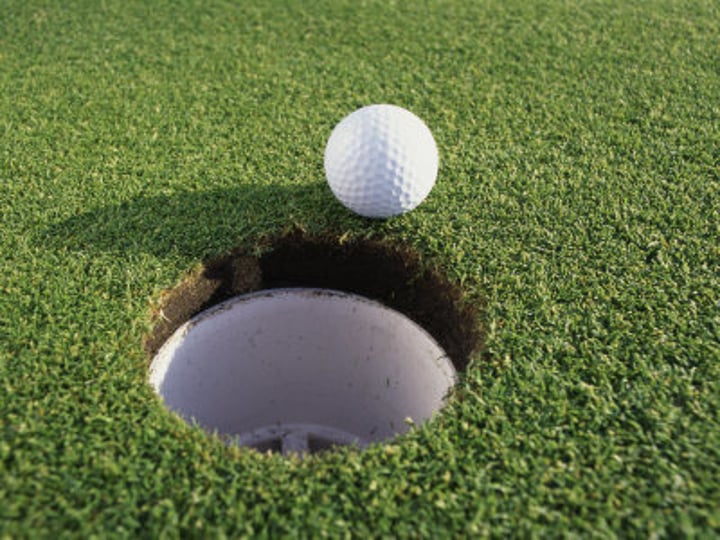 <p>The ball is ___ the hole.</p>