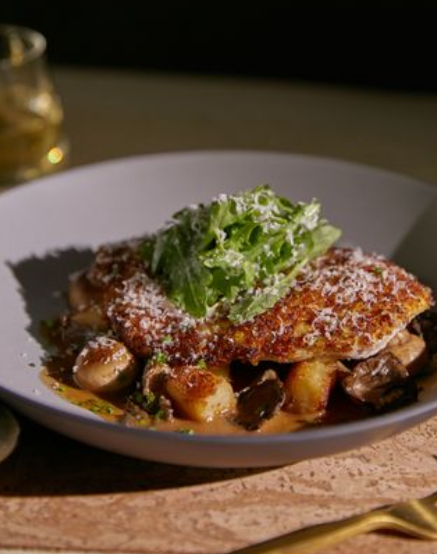<p><span>parmesan crusted chicken breast, roasted and grilled mushrooms, potato gnocchi, truffle mushroom cream sauce, arugula, lemon juice, grana padano cheese, red wine demi glace.</span></p><p><span><em>These ingredients combine perfectly to result in an earthy, flavourful, and sure-to-be guest favourite dish.</em></span></p>
