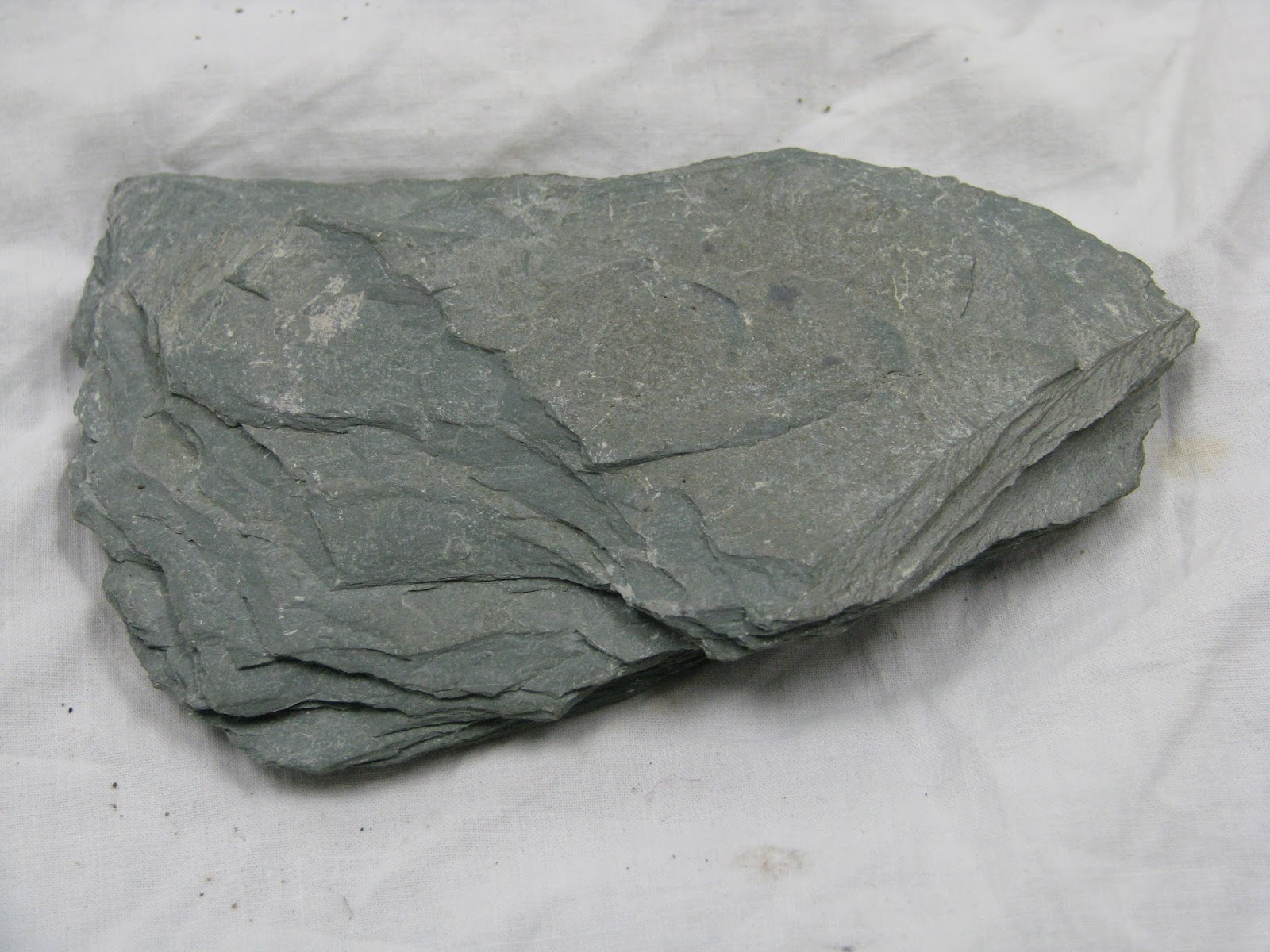 <ul><li><p>low grade</p></li><li><p>very fine grained</p></li><li><p>slaty cleavage</p></li><li><p>dark grey rock </p></li><li><p>dull lustre</p></li><li><p>protolith: shale</p></li><li><p>associated minerals: chlorite, muscovite</p></li></ul><p></p>