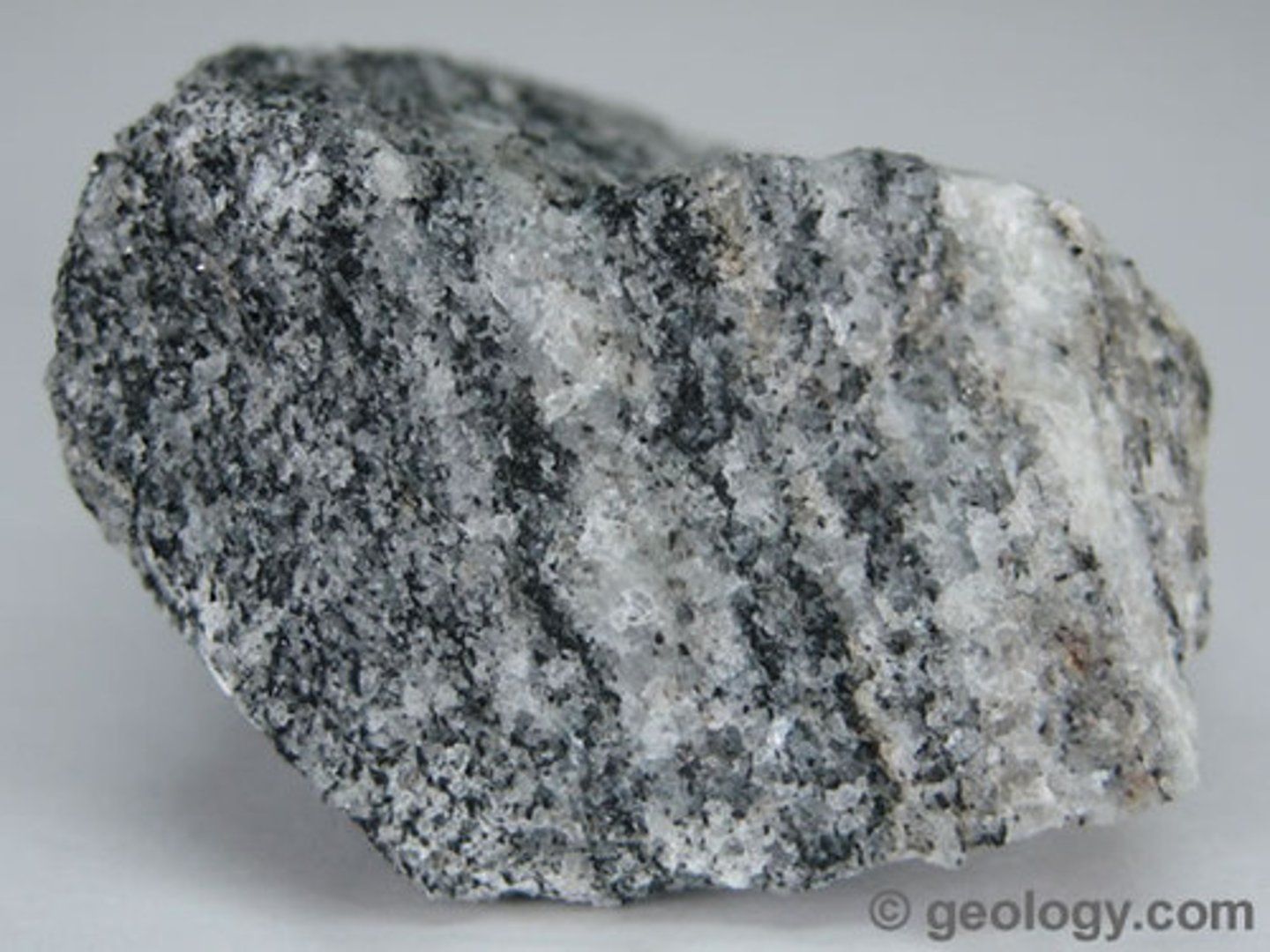 <p>metamorphic rock, banded appearance, granular mineral grains, contains quartz or feldspar minerals</p>