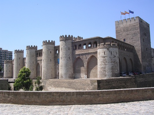 <ul><li><p><strong>Another example of Spanish Umayyad “pleasure palace”</strong></p></li><li><p>Had its own mosque</p><ul><li><p>Entrance into the mosque, showing typical Spanish Umayyad decorative motifs</p></li><li><p><strong>Like Cordoba, mihrab is a room, rather than a nich</strong></p><ul><li><p><strong>Unlike Cordoba (decorated with mosaics), stucco is used (painted) – reminiscent of Visgoth designs</strong></p></li></ul></li></ul></li><li><p>The dome has a transitional zone with spolia columns, polylobed arches, and windows between the walls of the room and the dome</p><ul><li><p><span style="font-family: Aptos, sans-serif">Another example of the “riffs” on Spanish Umayyad design at Aljafería: deeply cut polylobed arch with lace-like relief work around it, and spolia columns beneath</span></p></li></ul></li></ul><p></p>