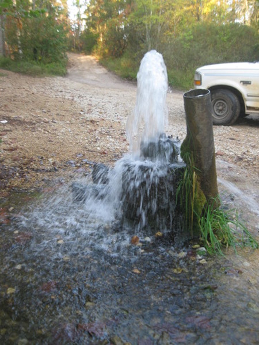 <p>Drilled hole in a confined aquifer releases pressure and pushes water up.</p>