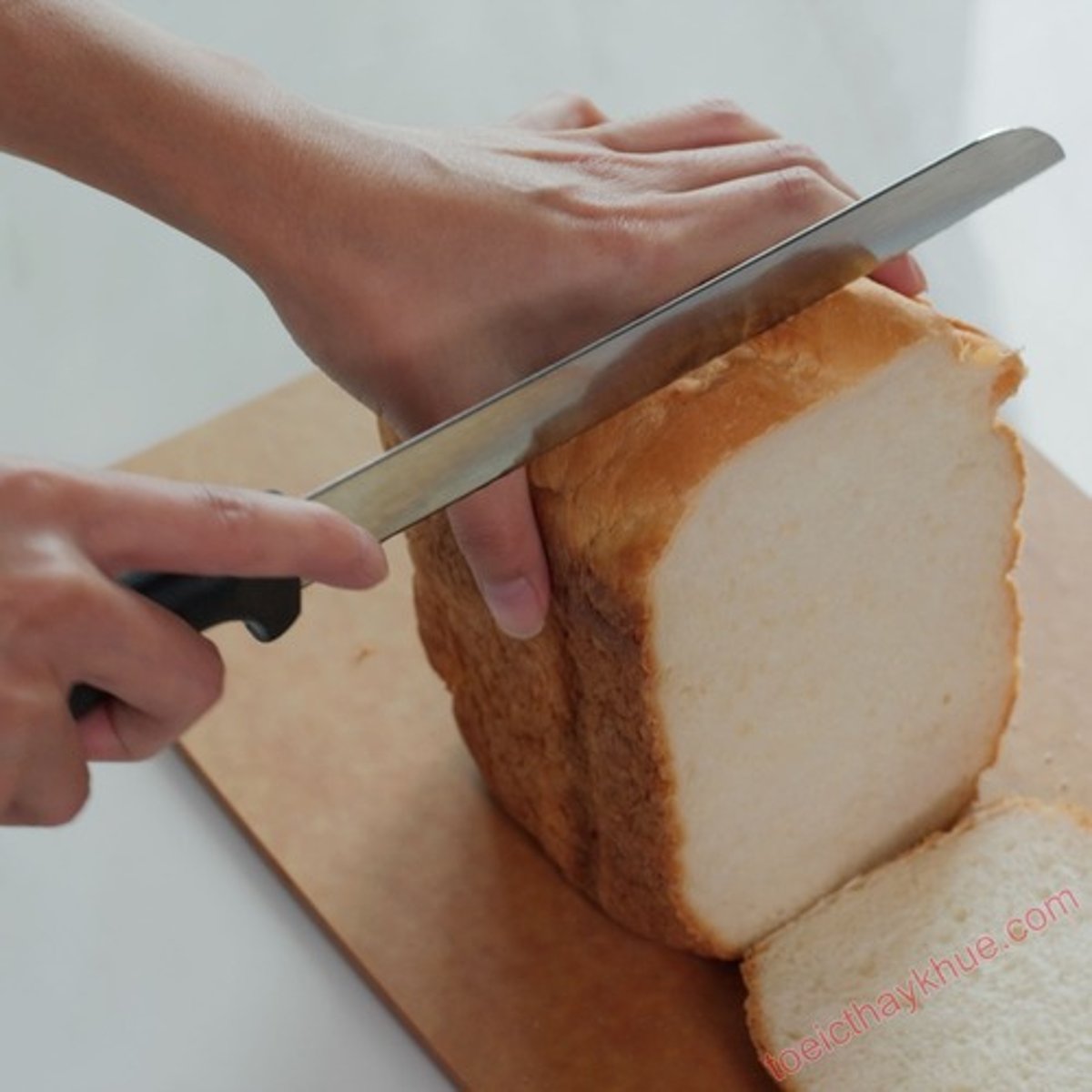 <p>cắt bánh mì bằng dao</p>